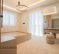Bedroom in a family house with a bed, tables, and curtains, floor with wooden decor.