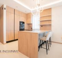 A kitchen in a family house with a wooden decor floor and pendant lighting.