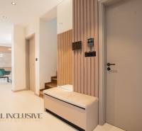 The interior of a family house with wooden decor, a staircase, and modern furniture.