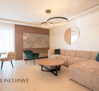 Living room in a family house with a beige sofa, green armchair, and a round table.