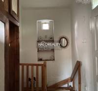 A staircase in a family house with wall decorations and wooden railing.