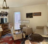 Living room in a family house with retro furniture, a sofa, and a tiled stove.