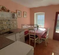A kitchen in a family house with colorful tiles and a dining area with a view.