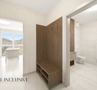 Entrance hall with a bench and a bathroom in a 2-room apartment with a wooden decor floor.