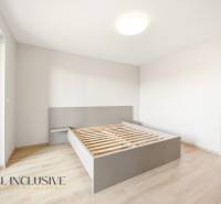 A bedroom in a 2-room apartment with a bed and a floor with a wood decor.