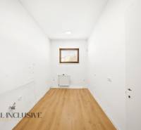 Commercial spaces with white walls and wood-patterned flooring.