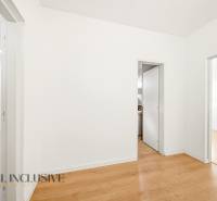 White walls, wood-patterned flooring, and two open doors in commercial premises.