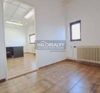 Interior of offices with brown tiles, a radiator, and well-lit rooms.