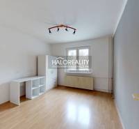 A bright room in a 2-room apartment with a wood-patterned floor and simple furniture.