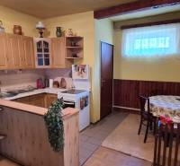 A kitchen in a family house with wooden cabinets and a dining table.