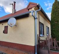 A family house in Holiare surrounded by greenery, with a satellite dish on the facade.