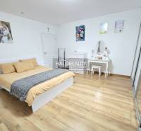 A bedroom with a bed, a wardrobe, and a wooden decor floor in a 3-room apartment.