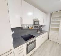 Interior of a 2-room apartment with a wooden decor floor, kitchen, and living room.