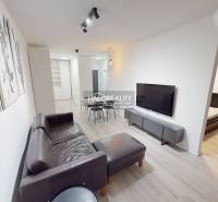 Living room with a leather sofa in a two-room apartment and a floor with a wooden decor.
