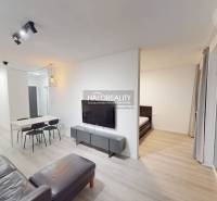 Hallway of a 2-room apartment with a wooden decor floor, bathroom, and dining table.