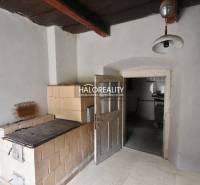 Traditional interior with a tiled stove and wooden ceiling.