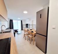 A spacious kitchen with a dining table and a sofa in a 2-room apartment.