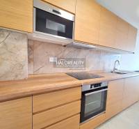 A kitchen with a dining area in a 2-room apartment, flooring with a wooden decor.