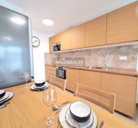 A kitchen in a 2-room apartment with wooden decor and a dining table.