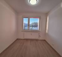 A room with white walls and a wooden decor floor in a 3-room apartment.
