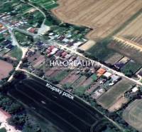 A view of plots prepared for housing in Horná Krupá surrounded by fields and houses.