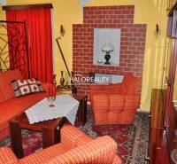 Living room with red sofas, carpet, and a brick fireplace in a family house.