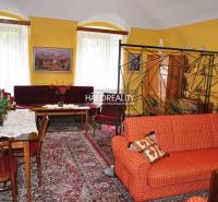 A living room in a family house with a sofa, a coffee table, and curtains, creating a cozy space.