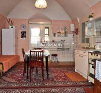 A kitchen in a family house with vintage decor, a wooden cabinet, and carpets.
