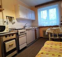 Kitchen in a 2-room apartment with a gas stove, dining table, and microwave.