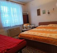 Bedroom in a 2-room apartment with a bed, carpet, and window radiator.