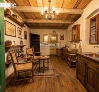 A rustic room with ceiling beams, a wooden decor floor, and historical furniture.