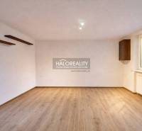 A spacious room with a light wood-patterned floor in a 4-room apartment.