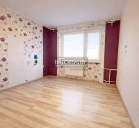 A room in a 4-room apartment with floral wallpaper and a wood-patterned floor.