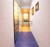 A hallway with blue tiles and glass doors in a 4-room apartment.