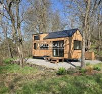 A small wooden house on a plot surrounded by trees in the recreational area of Zalaby.