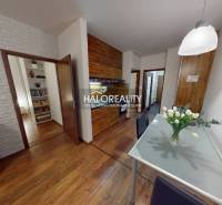 Interior of a 3-room apartment with decorative walls, wood-patterned flooring, and a glass table.