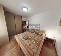 A bedroom in a 3-room apartment with wooden decor, a bed, and a wardrobe.