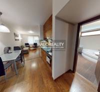 Interior of a 3-room apartment with a wooden decor floor, kitchen, and bathroom with a corner bathtub.