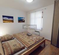 Bedroom with a double bed, light walls, and a floor with a wood decor in a 3-room apartment.