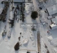 Winter landscape in Liptovské Beharovce, snow-covered plots - housing, houses, and trees from above.