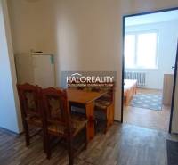 A kitchen in a 2-room apartment with a wooden decor and a dining table.