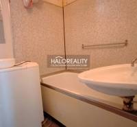 Bathroom in a 2-room apartment with a bathtub, sink, and washing machine.