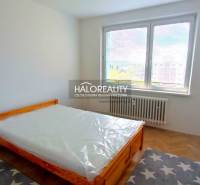 Bedroom in a 2-room apartment with a bed and a wooden decor floor.