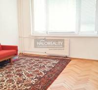 Living room in a 3-room apartment with a red sofa and patterned carpet.