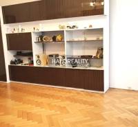 Living room wall unit with cabinets and wooden decor flooring in a 3-room apartment.