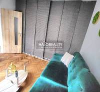 Living room with a turquoise sofa, wooden-patterned floor, and a coffee table.