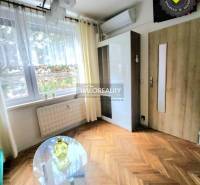 Interior of a 1-room apartment with installed air conditioning and wooden decor flooring.