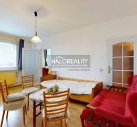 Living room in a three-room apartment with a wooden decor floor, sofa, and table.