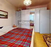 A bedroom in a 3-room apartment with a bed, a wardrobe, and a picture on the wall.