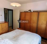 A bedroom in a 3-room apartment with wooden wardrobes and a ceiling lamp.